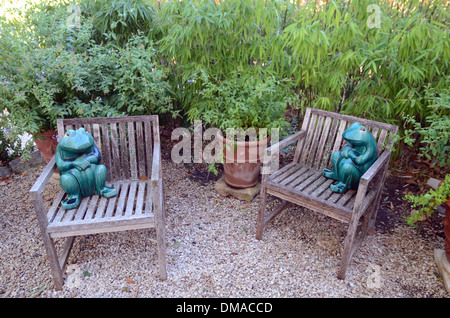 Garten Stühle & lustige ornamentalen Frösche in Kies Terrasse Garten Château d'Arnajon Le Puy-Sainte-Réparade Frankreich Stockfoto