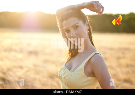 Junge Frau im Kleid stehen in einem Maisfeld bei Sonnenuntergang Stockfoto