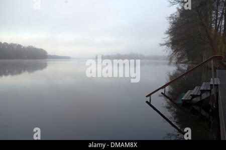 Motzen, Deutschland. 13. Dezember 2013. Der Nebel Slowley klärt über dem See in Motzen, Deutschland, 13. Dezember 2013. Berlin war am Freitagmorgen in dichten Nebel gehüllt. Foto: BERND VON JUTRCZENKA/Dpa/Alamy Live-Nachrichten Stockfoto