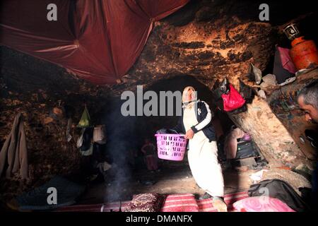Hebron, Westjordanland, Palästinensische Gebiete. 13. Dezember 2013. Eine Palästinenserin arbeitet in einer Höhle, wo sie am 13. Dezember 2013 im Dorf al-Mufaqara, südlich von Hebron, Westjordanland leben. Die Hügel von Jerusalem wurde heute durch seine heftigsten Schneesturm in Jahren mit ihrem Bürgermeister rief die Armee zu gestrandete Autofahrern helfen gelähmt. Ramallah und Bethlehem, palästinensische Städte in der Nähe von Jerusalem, wurden auch im Schnee überzogen und einige tiefer liegende Gebiete erlitt Überschwemmungen durch Starkregen Credit: Mamoun Wazwaz/APA Images/ZUMAPRESS.com/Alamy Live News Stockfoto