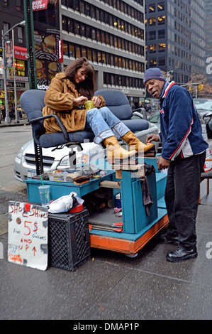 Ein Mann auf der Sixth Avenue in Midtown Manhattan scheint ein Tourist Stiefel in seiner Bordsteinkante Kabine Stockfoto