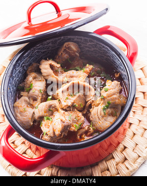 Geschmortes Hähnchen Keulen in rot Pfanne auf der Matte Stockfoto