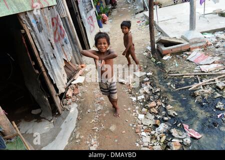 Phnom Penh, Kambodscha. 10. Dezember 2013. Kinder sind in dem Slum "Andong Bei Dorf", d.h. "Beautiful" in Phnom Penh, Kambodscha, 10. Dezember 2013 abgebildet. Kambodscha ist eines der 20 Länder mit den höchsten Raten von Unterernährung bei Kindern. Rund 670.000 Waisenkinder leben in Kambodscha. Jedes 22. Kind stirbt im ersten Jahr des Lebens. Mehr als ein Drittel der Bevölkerung lebt von weniger als einem Dollar pro Tag. Foto: Jens Kalaene/Dpa/Alamy Live News Stockfoto