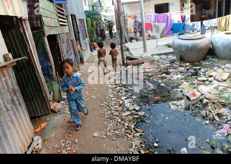 Phnom Penh, Kambodscha. 10. Dezember 2013. Kinder sind in dem Slum "Andong Bei Dorf", d.h. "Beautiful" in Phnom Penh, Kambodscha, 10. Dezember 2013 abgebildet. Kambodscha ist eines der 20 Länder mit den höchsten Raten von Unterernährung bei Kindern. Rund 670.000 Waisenkinder leben in Kambodscha. Jedes 22. Kind stirbt im ersten Jahr des Lebens. Mehr als ein Drittel der Bevölkerung lebt von weniger als einem Dollar pro Tag. Foto: Jens Kalaene/Dpa/Alamy Live News Stockfoto