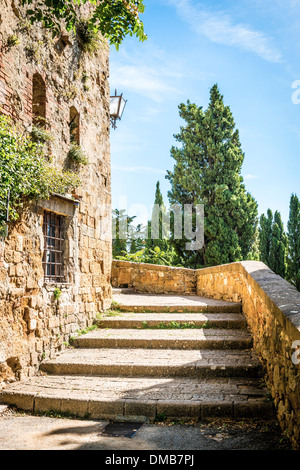 Kleine Straße mit einer Treppe in Pienza Toskana, Italien im Sommer bei blauem Himmel Stockfoto