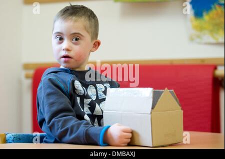 Dresden, Deutschland. 5. Dezember 2013. Fünf-jährige Valentino mit Down Syndrom sitzt während der Ergotherapie in einem Therapieraum im Sociopediatric-Zentrum (SPZ) am Klinikum Dresden-Neustadt in Dresden, Deutschland, 5. Dezember 2013. (Model-Release verfügbar) Foto: Sebastian Kahnert/Dpa/Alamy Live News Stockfoto