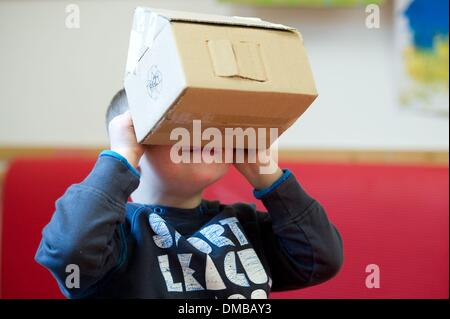 Dresden, Deutschland. 5. Dezember 2013. Fünf-jährige Valentino mit Down Syndrom sitzt während der Ergotherapie in einem Therapieraum im Sociopediatric-Zentrum (SPZ) am Klinikum Dresden-Neustadt in Dresden, Deutschland, 5. Dezember 2013. (Model-Release verfügbar) Foto: Sebastian Kahnert/Dpa/Alamy Live News Stockfoto