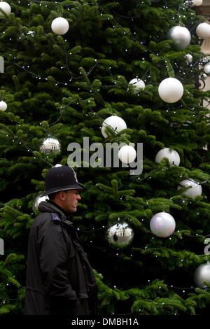 Westminster London, 13. Dezember 2013. Ein Polizist geht vorbei an einem Weihnachtsbaum steht außerhalb der Residenz des Ministerpräsidenten in der Nummer 10 Downing Street. Der Baum wurde in einem Nationalbaum Wettbewerb gewann von Oxfordshire Züchter Andrew Ingram Credit gewählt: Amer Ghazzal/Alamy Live-Nachrichten Stockfoto