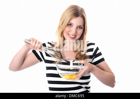 Junge Frau mischen Eiern Stockfoto