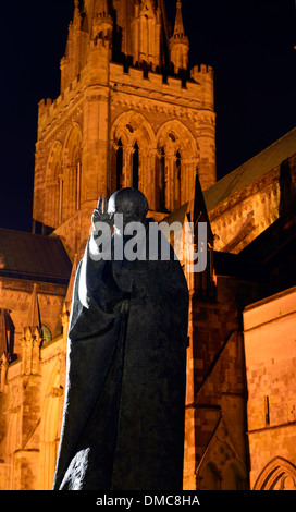 Die Statue des Heiligen Richard von Phillip Jackson vor einem beleuchteten Chichester Kathedrale bei Nacht, West Sussex, UK Stockfoto