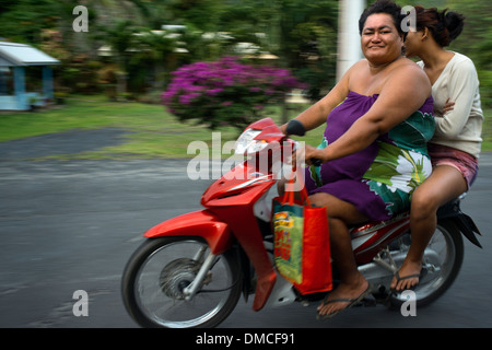 Rarotonga-Insel. Cook Island. Polynesien. Süd-Pazifik. Zwei übergewichtige Menschen fahren Sie ein Motorrad auf einer Straße auf der Insel Stockfoto