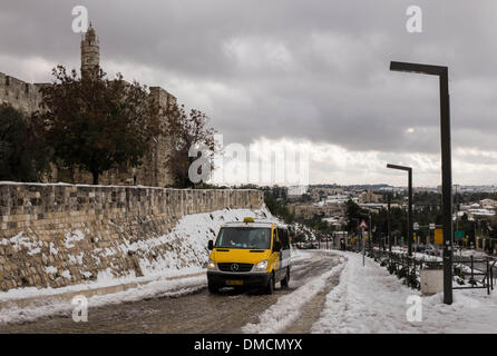 Jerusalem, Israel. 13. Dezember 2013. Ein Taxi führt vorbei an der Turm von David in der Altstadt von Jerusalem. Ein schwerer Sturm in Israel, für drei Tage am Stück, laufende lähmt den Verkehr landesweit mit Tel Aviv Flughafen heruntergefahren und Soldaten entsandt, um gestrandete Fahrer auf Autobahnen zu retten. Polizei riefen sagen auf eisigen Straßen eine "real Life Bedrohung" in was Meteorologen betitelt als der stärkste Schneesturm seit 1953 sein kann auf die Bürger zu Hause, zu bleiben. Jerusalem ist mit Schnee bedeckt und alle Eintrag Straßen blockiert sind. Bildnachweis: Xinhua/Alamy Live-Nachrichten Stockfoto