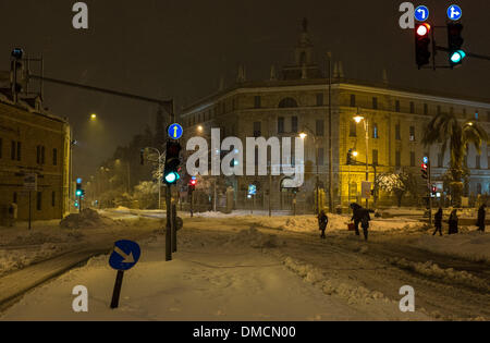 Jerusalem, Israel. 13. Dezember 2013. Fußgänger gehen vorbei an einer schneebedeckten Straße in Jerusalem. Ein schwerer Sturm in Israel, für drei Tage am Stück, laufende lähmt den Verkehr landesweit mit Tel Aviv Flughafen heruntergefahren und Soldaten entsandt, um gestrandete Fahrer auf Autobahnen zu retten. Polizei riefen sagen auf eisigen Straßen eine "real Life Bedrohung" in was Meteorologen betitelt als der stärkste Schneesturm seit 1953 sein kann auf die Bürger zu Hause, zu bleiben. Jerusalem ist mit Schnee bedeckt und alle Eintrag Straßen blockiert sind. Bildnachweis: Xinhua/Alamy Live-Nachrichten Stockfoto