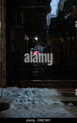 Jerusalem, Israel. 13. Dezember 2013. Eine Mädchen hält ihren Schirm im Schnee in der Altstadt von Jerusalem. Ein schwerer Sturm in Israel, für drei Tage am Stück, laufende lähmt den Verkehr landesweit mit Tel Aviv Flughafen heruntergefahren und Soldaten entsandt, um gestrandete Fahrer auf Autobahnen zu retten. Polizei riefen sagen auf eisigen Straßen eine "real Life Bedrohung" in was Meteorologen betitelt als der stärkste Schneesturm seit 1953 sein kann auf die Bürger zu Hause, zu bleiben. Jerusalem ist mit Schnee bedeckt und alle Eintrag Straßen blockiert sind. Bildnachweis: Xinhua/Alamy Live-Nachrichten Stockfoto