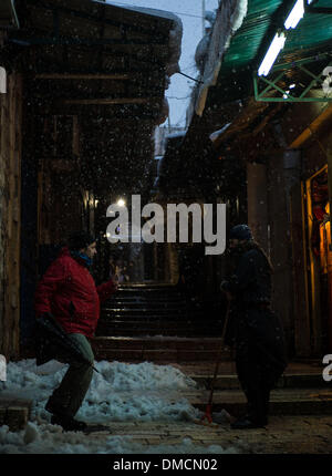 Jerusalem, Israel. 13. Dezember 2013. Ein Passant (L) spricht mit einem Einheimischen im Schnee in der Altstadt von Jerusalem. Ein schwerer Sturm in Israel, für drei Tage am Stück, laufende lähmt den Verkehr landesweit mit Tel Aviv Flughafen heruntergefahren und Soldaten entsandt, um gestrandete Fahrer auf Autobahnen zu retten. Polizei riefen sagen auf eisigen Straßen eine "real Life Bedrohung" in was Meteorologen betitelt als der stärkste Schneesturm seit 1953 sein kann auf die Bürger zu Hause, zu bleiben. Jerusalem ist mit Schnee bedeckt und alle Eintrag Straßen blockiert sind. Bildnachweis: Xinhua/Alamy Live-Nachrichten Stockfoto