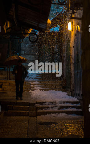 Jerusalem, Israel. 13. Dezember 2013. Ein Mann hält seinen Regenschirm in der Altstadt von Jerusalem. Ein schwerer Sturm in Israel, für drei Tage am Stück, laufende lähmt den Verkehr landesweit mit Tel Aviv Flughafen heruntergefahren und Soldaten entsandt, um gestrandete Fahrer auf Autobahnen zu retten. Polizei riefen sagen auf eisigen Straßen eine "real Life Bedrohung" in was Meteorologen betitelt als der stärkste Schneesturm seit 1953 sein kann auf die Bürger zu Hause, zu bleiben. Jerusalem ist mit Schnee bedeckt und alle Eintrag Straßen blockiert sind. Bildnachweis: Xinhua/Alamy Live-Nachrichten Stockfoto