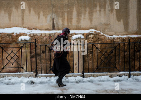 Jerusalem, Israel. 13. Dezember 2013. Eine muslimische Frau Spaziergänge im Schnee in der Altstadt von Jerusalem. Ein schwerer Sturm in Israel, für drei Tage am Stück, laufende lähmt den Verkehr landesweit mit Tel Aviv Flughafen heruntergefahren und Soldaten entsandt, um gestrandete Fahrer auf Autobahnen zu retten. Polizei riefen sagen auf eisigen Straßen eine "real Life Bedrohung" in was Meteorologen betitelt als der stärkste Schneesturm seit 1953 sein kann auf die Bürger zu Hause, zu bleiben. Jerusalem ist mit Schnee bedeckt und alle Eintrag Straßen blockiert sind. Bildnachweis: Xinhua/Alamy Live-Nachrichten Stockfoto