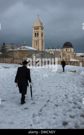 Jerusalem, Israel. 13. Dezember 2013. Orthodoxe Juden gehen im Schnee in der Altstadt von Jerusalem. Ein schwerer Sturm in Israel, für drei Tage am Stück, laufende lähmt den Verkehr landesweit mit Tel Aviv Flughafen heruntergefahren und Soldaten entsandt, um gestrandete Fahrer auf Autobahnen zu retten. Polizei riefen sagen auf eisigen Straßen eine "real Life Bedrohung" in was Meteorologen betitelt als der stärkste Schneesturm seit 1953 sein kann auf die Bürger zu Hause, zu bleiben. Jerusalem ist mit Schnee bedeckt und alle Eintrag Straßen blockiert sind. Bildnachweis: Xinhua/Alamy Live-Nachrichten Stockfoto