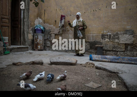 Kairo, Ägypten. 14. Dezember 2013. OM Mohamed und Sherif, 54, Arbeitslosen, RSS-Feeds Tauben vor dem Grab hält sie neben denen ihrer Familie mehr als 20 Jahren in Stadt der Toten, ein Flüchtling befindet sich in der Nähe von Alt-Kairo, Hauptstadt von Ägypten, am 12. Dezember 2013 gelebt hat. Stadt der Toten oder Qarafa Friedhof ist ein Flüchtling Stadtteil bestehend aus mehr als eine halbe million Einwohner, die entweder in den Zimmern, Mausoleen und Gräber angegliedert Leben oder ihre Unterstände auf Friedhöfen bauen. © Pan Chaoyue/Xinhua/Alamy Live-Nachrichten Stockfoto