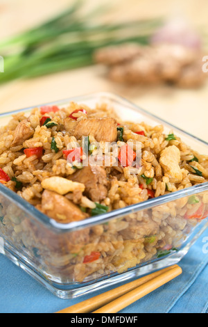 Hausgemachte Chinesisch gebratener Reis mit Gemüse, Huhn und Spiegeleier serviert in Glasschale mit Stäbchen auf der Seite Stockfoto