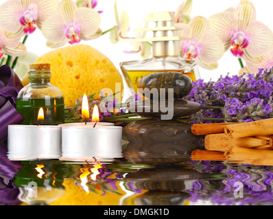 Zubehör für Spa mit Orchideen, Lavendel, Steinen, Schwamm, Kerzen und Zimt. Stockfoto