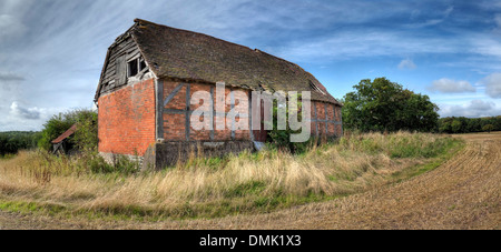 Überwucherten Fachwerk- und Backstein halb abgewalmt Scheune, Warwickshire, England. Stockfoto