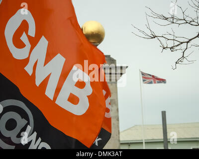 Portsmouth, UK. 14. Dezember 2013. Ein GMB Gewerkschaft Flagge weht außerhalb von Portsmouth Historic Dockyard als Hunderte von BAE Arbeiter protestieren gegen die mögliche Schließung der BAE-Schiffbau-Anlage. Bildnachweis: Simon Evans/Alamy Live News Stockfoto