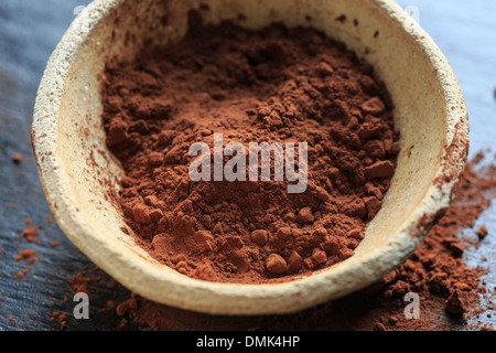 Kakaopulver in einer Schüssel auf schwarzem Hintergrund, Nahaufnahme Stockfoto