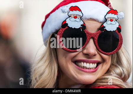 London, UK. 14. Dezember 2013.  Eine attraktive Frau mit Neuheit Weihnachten Brille Teilnahme an der diesjährigen Santacon.  Hunderte von Weihnachtsmänner sammeln auf den Stufen des St Pauls Cathedral, bevor sie ab März treffen sich mit Gruppen von anderen Weihnachtsmänner, die jährliche Santacon zu feiern.  Fotograf: Gordon Scammell/Alamy Live-Nachrichten Stockfoto