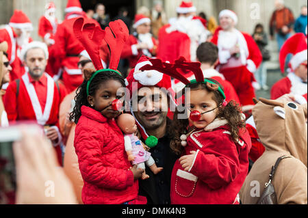 London, UK. 14. Dezember 2013.  Ein Mann und zwei Kindern, die Teilnahme an der diesjährigen Santacon.  Hunderte von Weihnachtsmänner sammeln auf den Stufen des St Pauls Cathedral, bevor sie ab März treffen sich mit Gruppen von anderen Weihnachtsmänner, die jährliche Santacon zu feiern.  Fotograf: Gordon Scammell/Alamy Live-Nachrichten Stockfoto