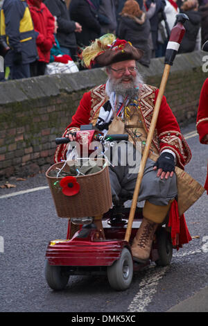 Wimborne, Dorset, Großbritannien. Dezember 2013. Die Zuschauer schauen sich die 25. Wimborne Save the Children Christmas Parade an. Wimborne Town Crier Chris Brown Reiten auf Mobility Scooter. Quelle: Carolyn Jenkins/Alamy Live News Stockfoto