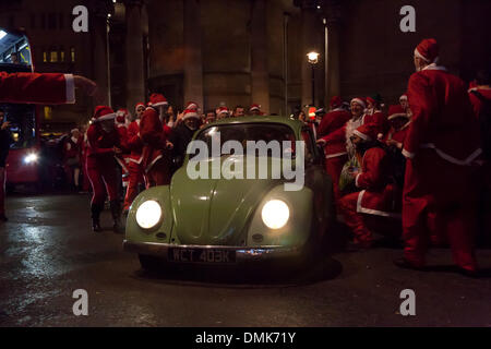 London, UK. 14. Dezember 2013 klassische VW-Käfer ist umgeben von den Hunderten von Feiernden der jährlichen Santa Con-Veranstaltung, die außen BBC Broadcasting House in Portland Place versammelt. Bildnachweis: Nelson Pereira/Alamy Live News Stockfoto