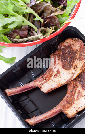 Rohe Lammkotelett bereit, in Kunststoff-Tablett mit Salat kochen. Stockfoto