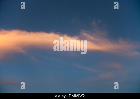 Wispy Wolkenformationen fangen die Farben der untergehenden Sonne. Stockfoto