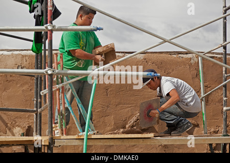 Freiwillige Dominic Bailon (links) und Brandon Calabazas arbeiten nach der Wiederherstellung der San Miguel Church, Santa Fe, New Mexico USA Stockfoto