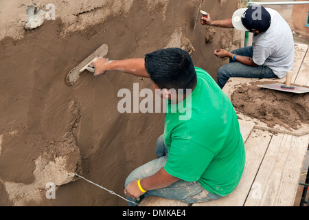 Freiwillige Dominic Bailon (links) und Brandon Calabazas arbeiten nach der Wiederherstellung der San Miguel Church, Santa Fe, New Mexico USA Stockfoto