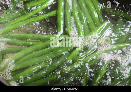 Frische grüne Bohnen kochen in Wasser auf Herd Stockfoto