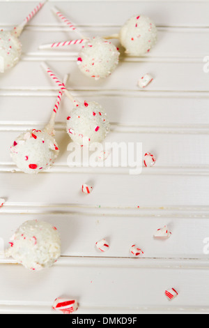 Pfefferminze, die Schoko-Cake pops in weißer Schokolade und Süßigkeiten Zuckerrohr Bits getaucht. Stockfoto