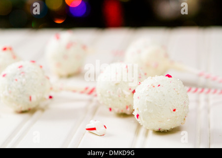 Pfefferminze, die Schoko-Cake pops in weißer Schokolade und Süßigkeiten Zuckerrohr Bits getaucht. Stockfoto