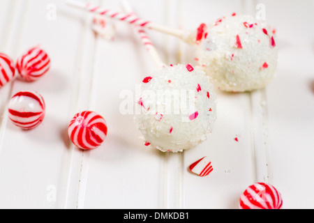 Pfefferminze, die Schoko-Cake pops in weißer Schokolade und Süßigkeiten Zuckerrohr Bits getaucht. Stockfoto