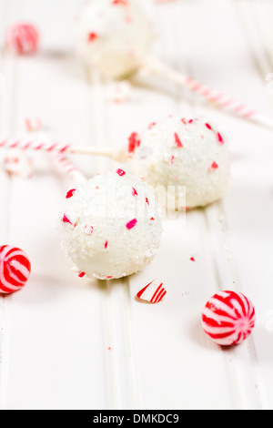 Pfefferminze, die Schoko-Cake pops in weißer Schokolade und Süßigkeiten Zuckerrohr Bits getaucht. Stockfoto