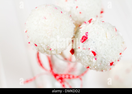 Pfefferminze, die Schoko-Cake pops in weißer Schokolade und Süßigkeiten Zuckerrohr Bits getaucht. Stockfoto