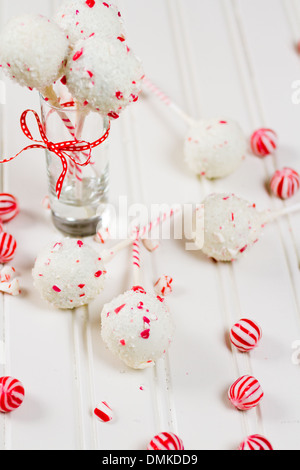 Pfefferminze, die Schoko-Cake pops in weißer Schokolade und Süßigkeiten Zuckerrohr Bits getaucht. Stockfoto