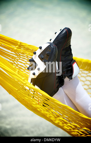 Nahaufnahme der Fußballspieler in Strand Hängematte entspannen Fußballschuhe Stockfoto