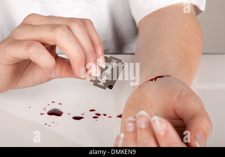 Selbstmordversuch einer Hand mit einer Rasierklinge Stockfoto