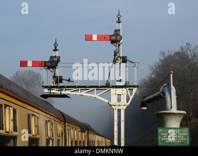 Semaphor Signale und Wasser Kran im Winter Nebel an Horsted Keynes-Station auf der Bluebell Railway, Sussex, England, UK Stockfoto