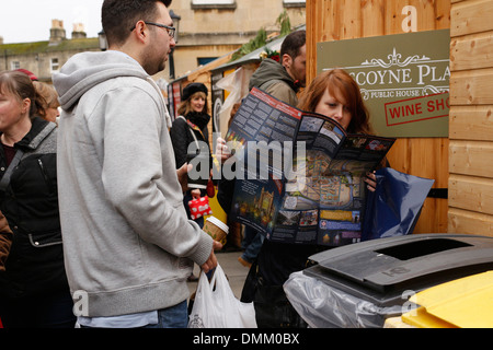 Junge Frau beim Auschecken ihre Straßenkarte auf dem Weihnachtsmarkt in der Stadt Bath, England, Dezember 2013 Stockfoto