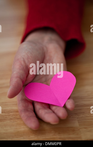 Frau mit Herz rosa Papier in der hand Stockfoto