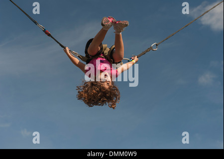 Ein Kind schwingt auf dehnbare Schnüre in einem lokalen Park in Zentral-Florida Stockfoto