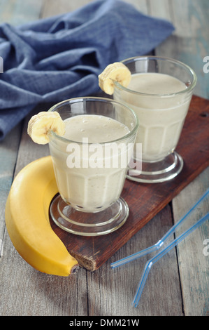 Banane Smoothie im Glas mit frischen Früchten auf hölzernen Hintergrund Stockfoto